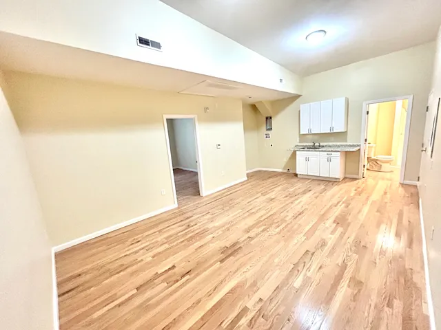 a large white kitchen with kitchen island a sink dishwasher and a refrigerator