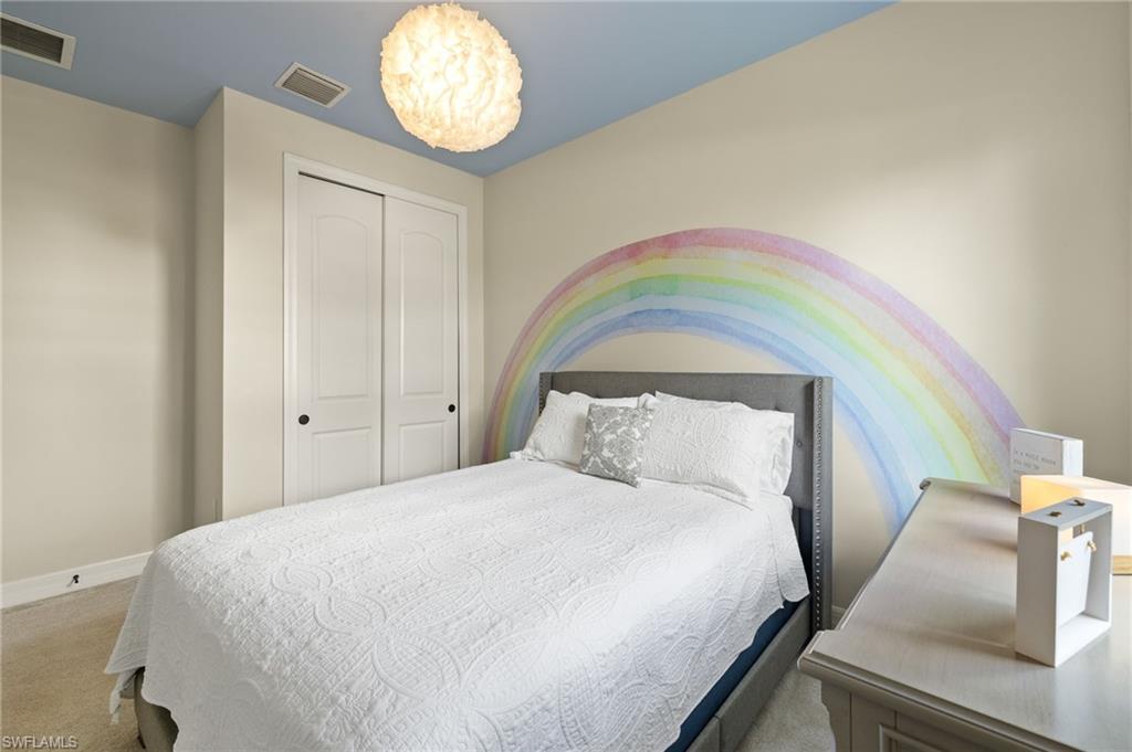 4424 Owens Way Ave Maria, FL 34142 - Photo 13 of 28 a bedroom with a bed and a chandelier
