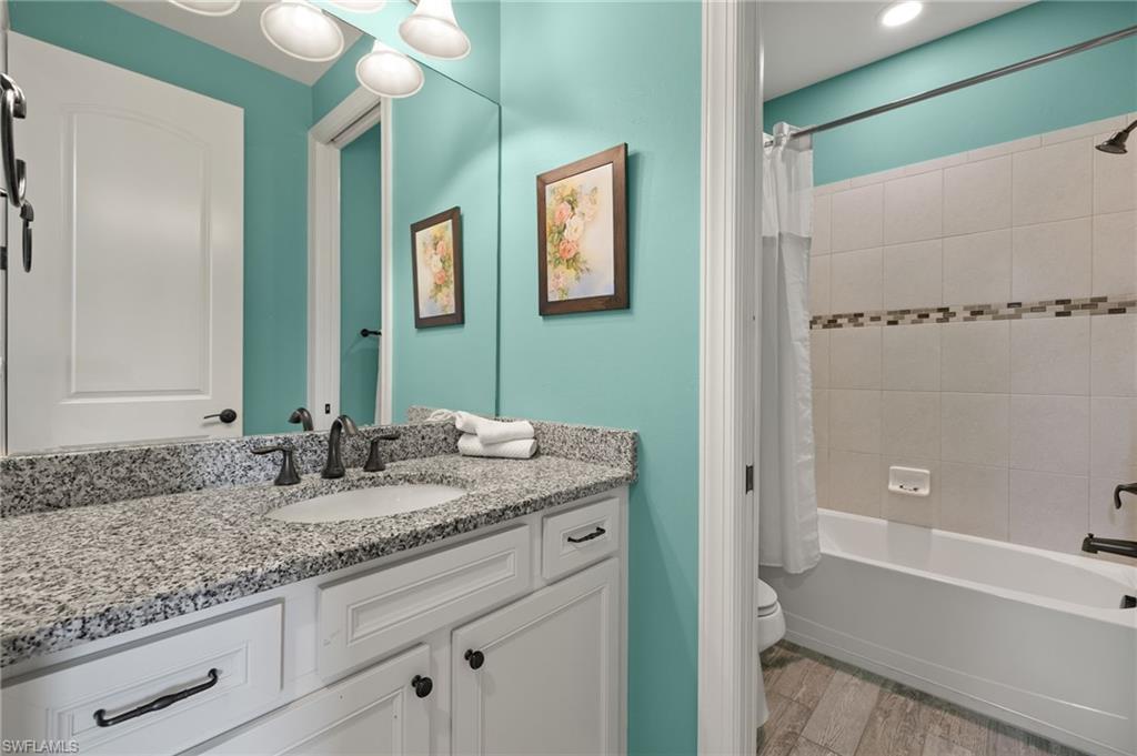 4424 Owens Way Ave Maria, FL 34142 - Photo 16 of 28 a bathroom with a granite countertop sink a mirror and a bathtub