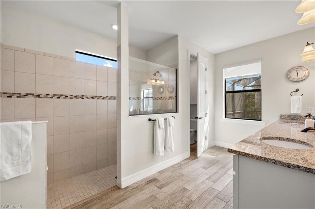 4424 Owens Way Ave Maria, FL 34142 - Photo 20 of 28 a bathroom with a granite countertop sink mirror and shower