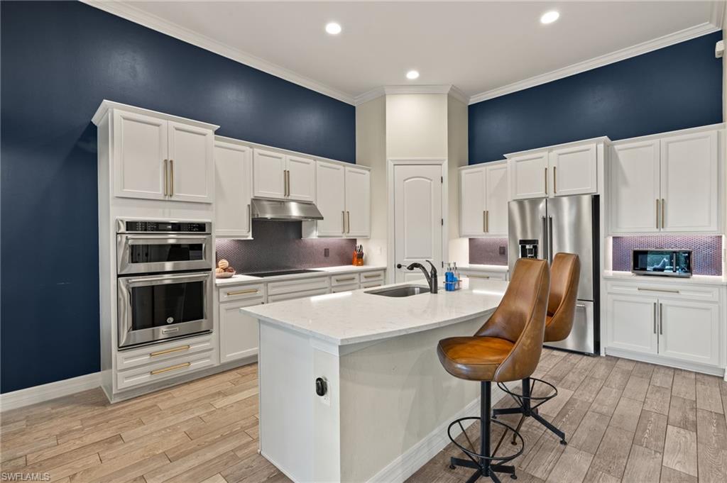 4424 Owens Way Ave Maria, FL 34142 - Photo 6 of 28 a kitchen with stainless steel appliances a stove a sink refrigerator and a chair