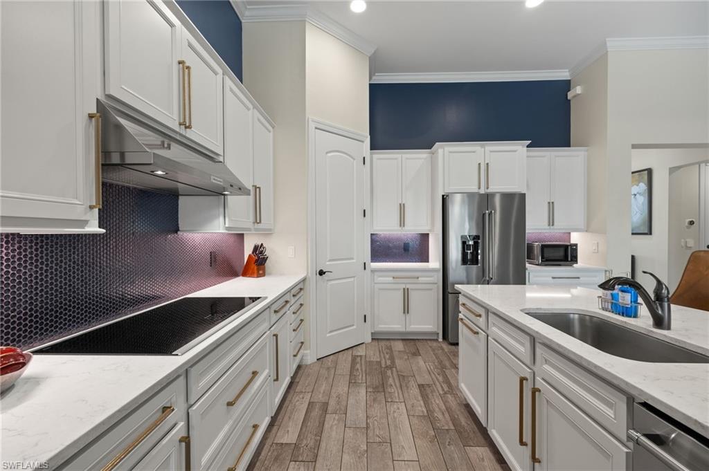 4424 Owens Way Ave Maria, FL 34142 - Photo 7 of 28 a kitchen that has a lot of cabinets a sink and appliances
