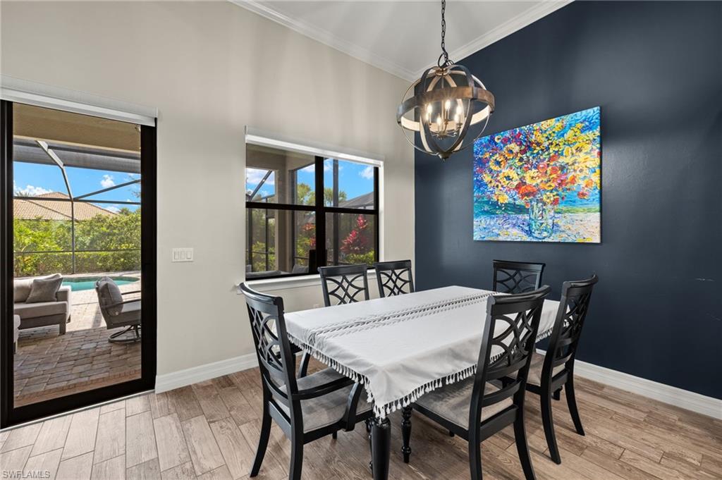 4424 Owens Way Ave Maria, FL 34142 - Photo 9 of 28 a view of a dining room with furniture a chandelier and wooden floor
