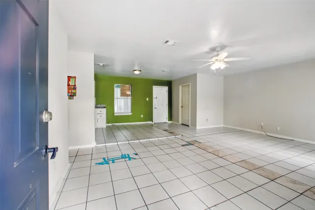 an empty room with windows and fan