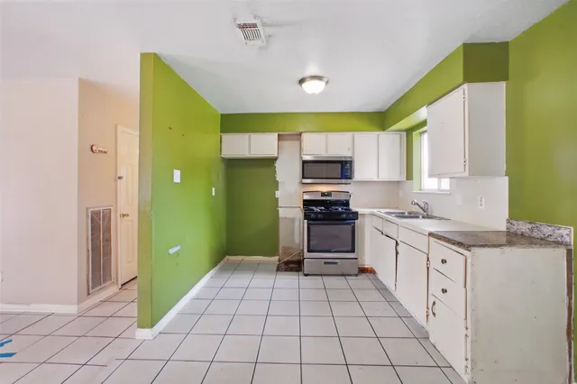 a view of kitchen with windows and refrigerator