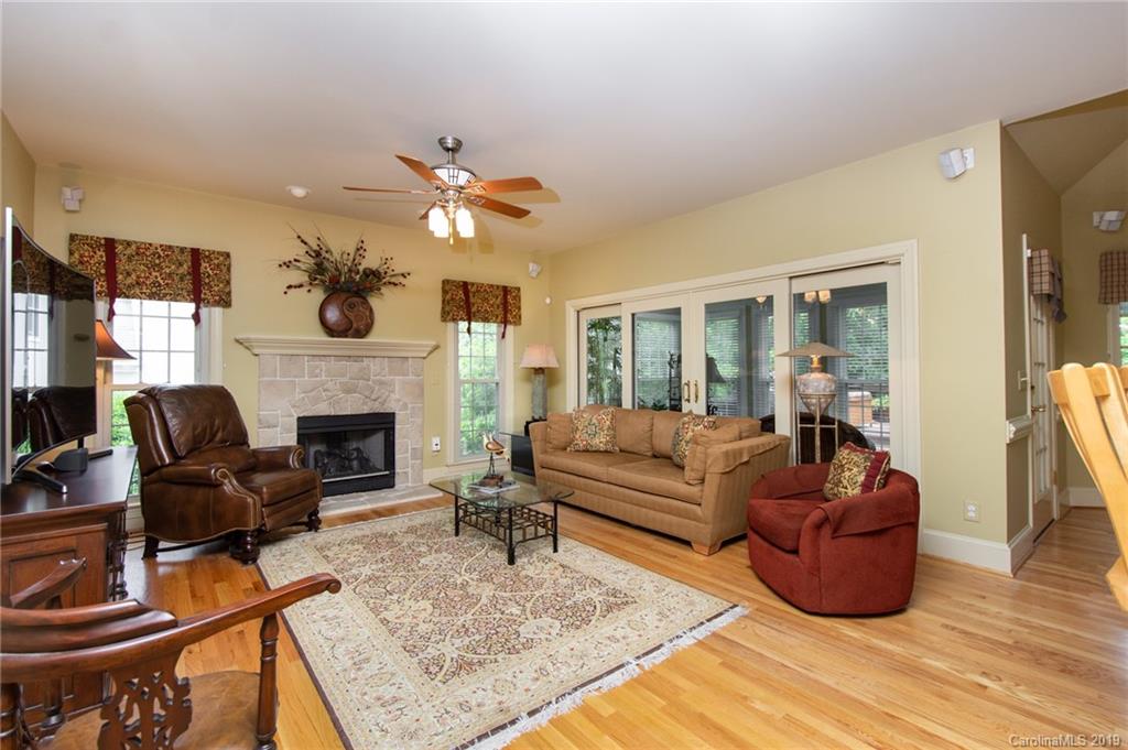 7074 Harbor Court Tega Cay, SC 29708 - Photo 9 of 36 a living room with furniture a dining table and a fireplace
