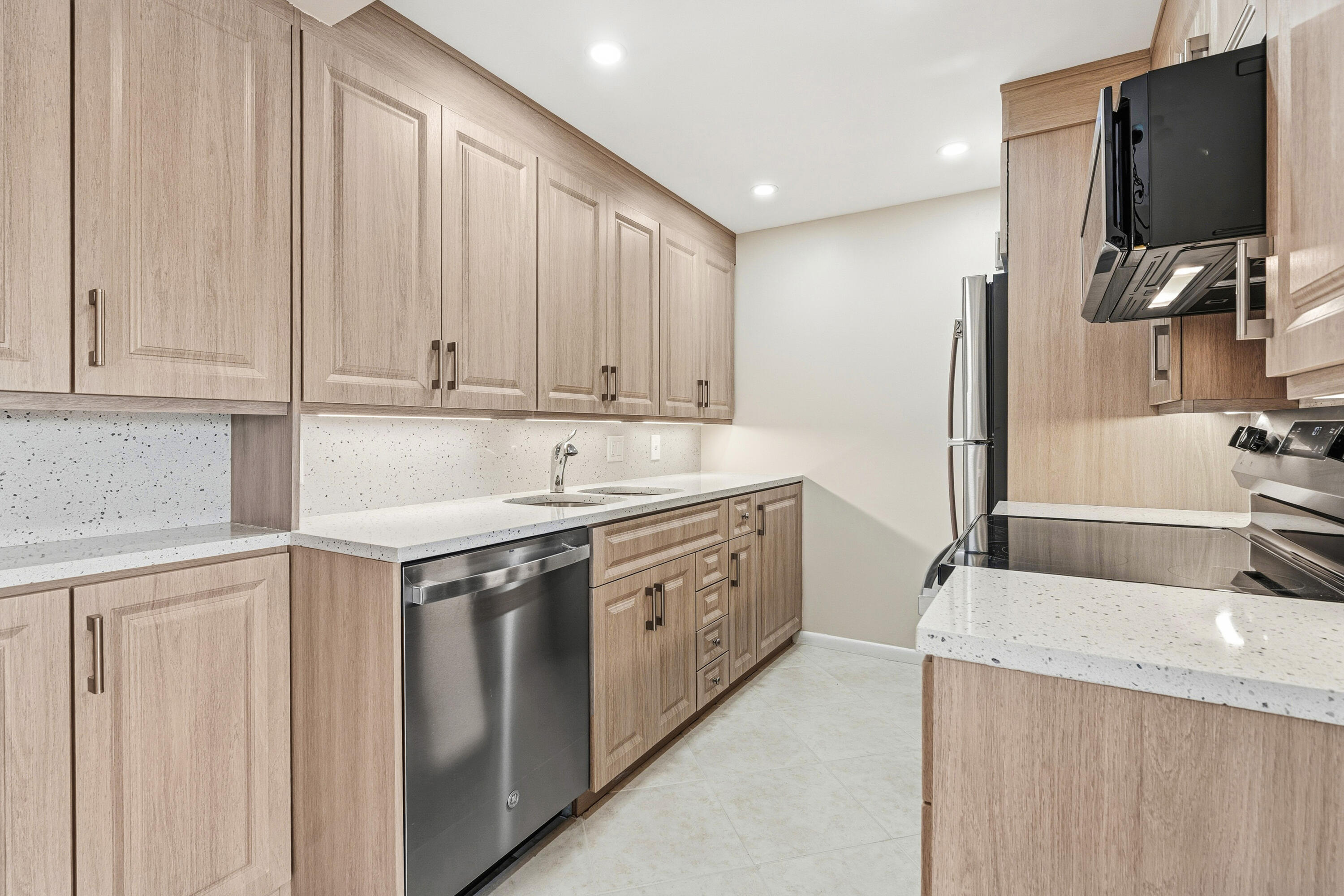 a kitchen with stainless steel appliances granite countertop a sink stove and refrigerator
