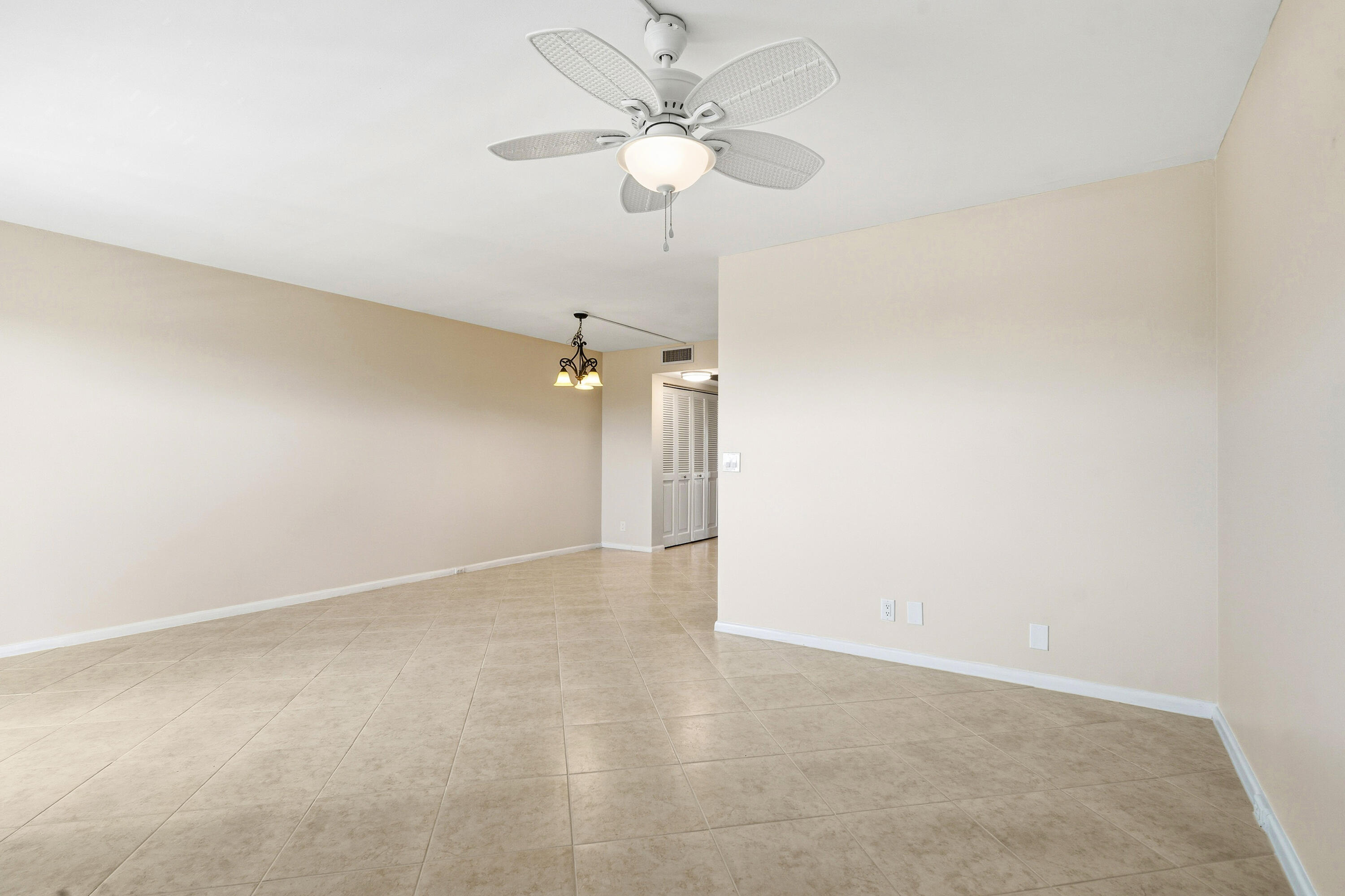 4067 Yarmouth C Boca Raton, FL 33434 - Photo 2 of 40 an empty room with a chandelier fan and a ceiling fan