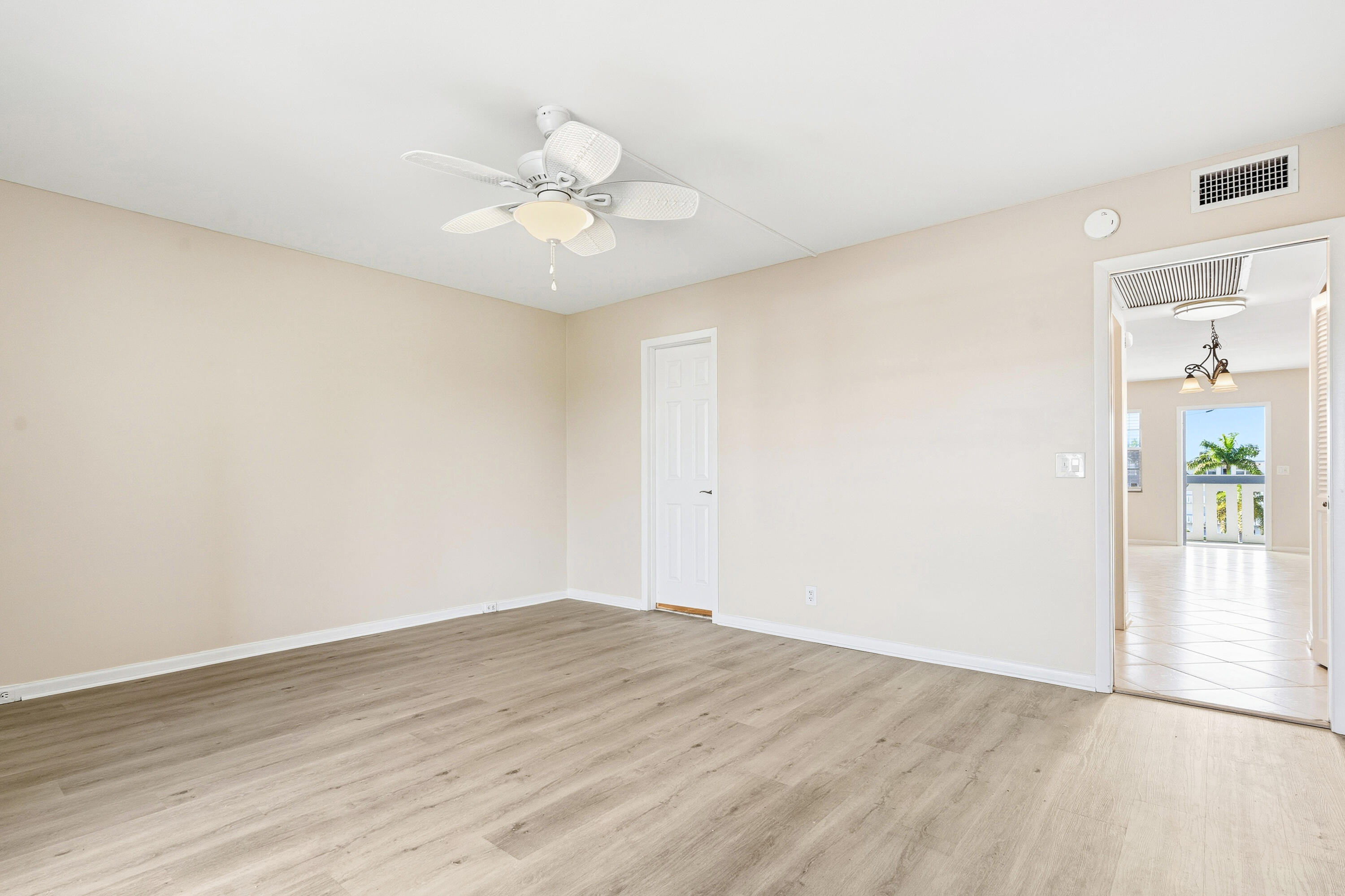 4067 Yarmouth C Boca Raton, FL 33434 - Photo 31 of 40 an empty room with wooden floor and hallway
