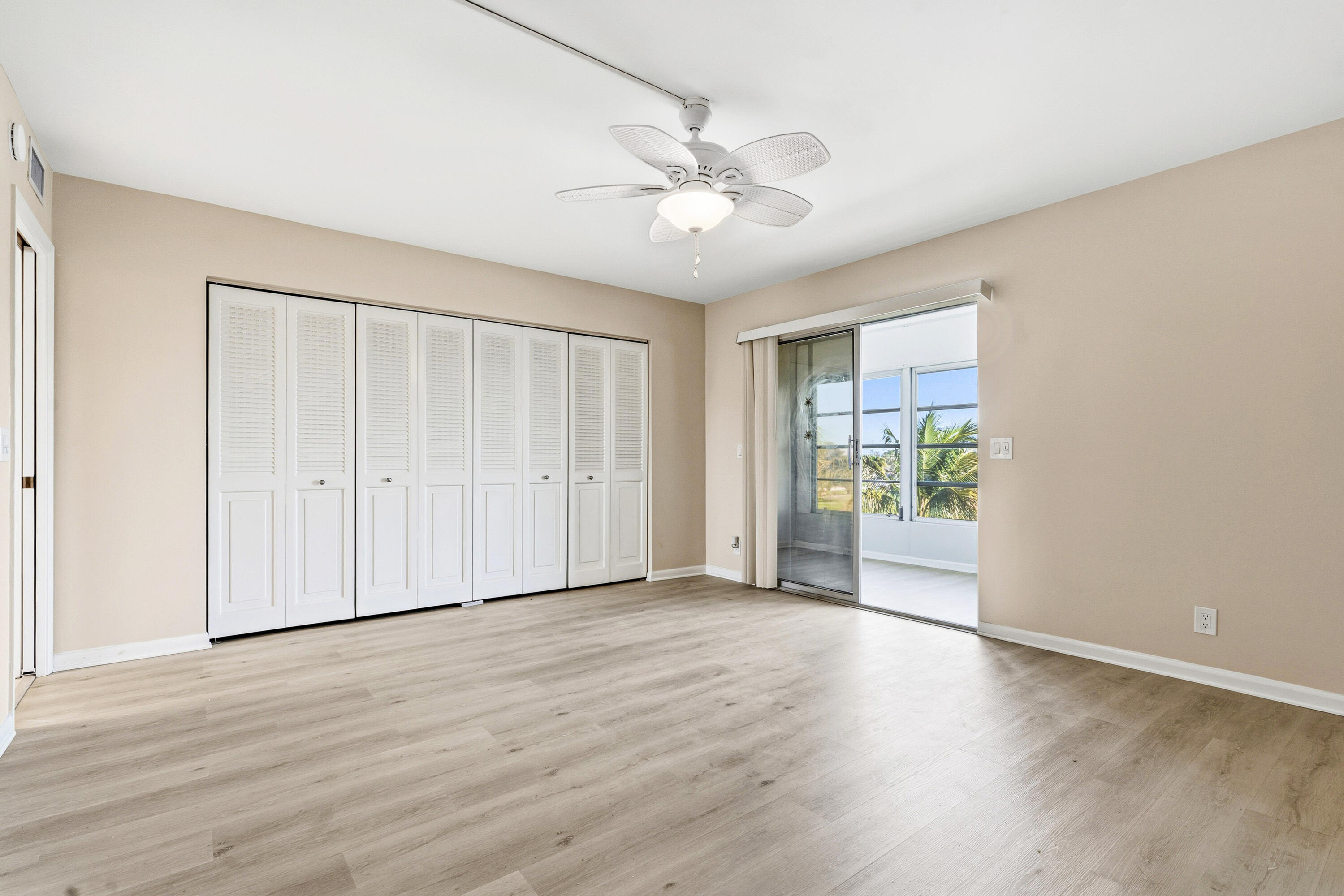 4067 Yarmouth C Boca Raton, FL 33434 - Photo 32 of 40 a view of an empty room with wooden floor and a window