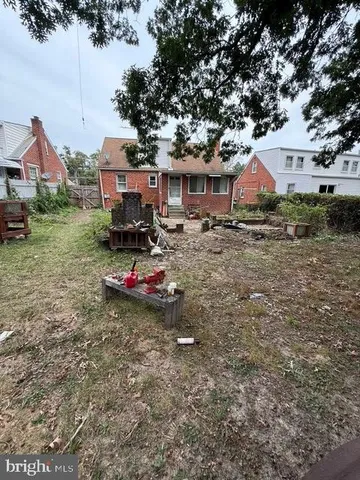 a view of a big yard with table and chairs under an umbrella