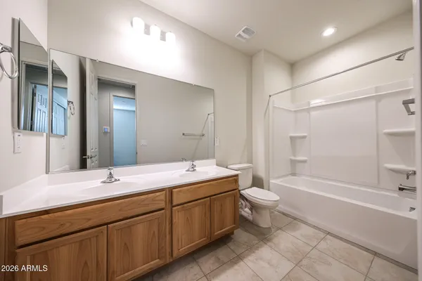 a bathroom with a double vanity sink toilet mirror and bathtub