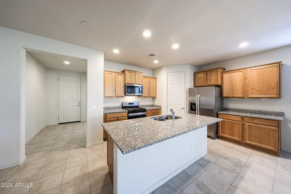 a open kitchen with stainless steel appliances granite countertop a stove refrigerator sink and cabinets