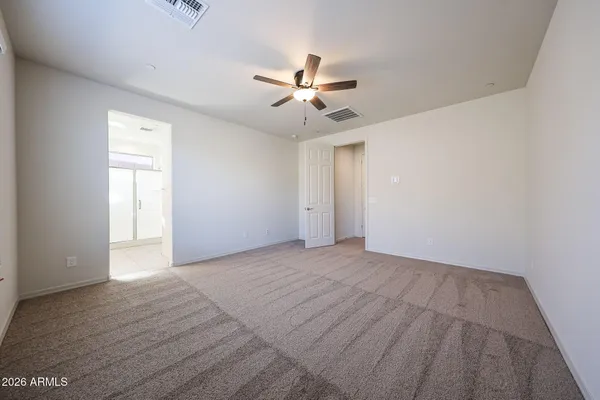 an empty room with fan and windows
