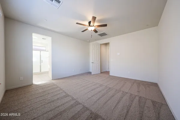 an empty room with fan and windows