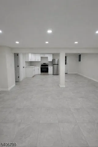 a view of an empty room with kitchen