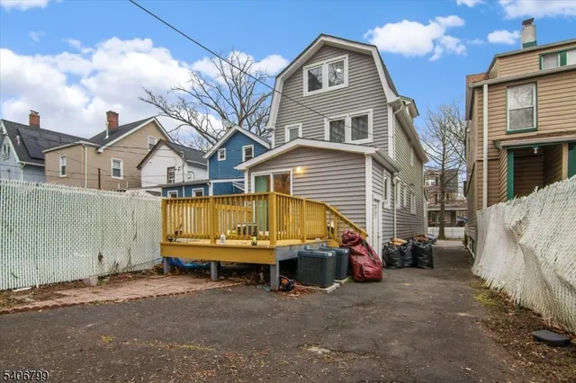 a view of a house with a yard and large tree