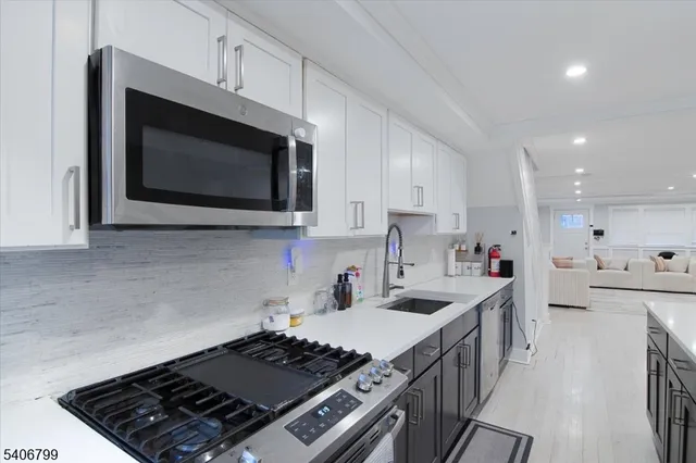 a kitchen with stainless steel appliances kitchen island granite countertop a sink stove and cabinets