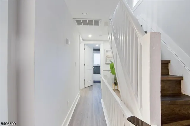 a view of a hallway with wooden floor and staircase