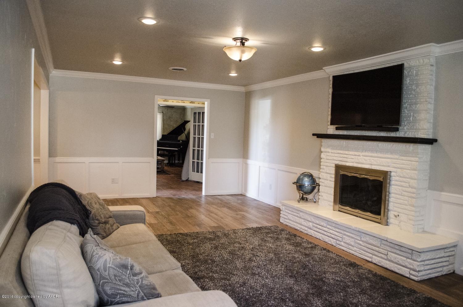 6312 Elmhurst Road Amarillo, TX 79106 - Photo 26 of 85 a living room with furniture a flat screen tv and a fireplace