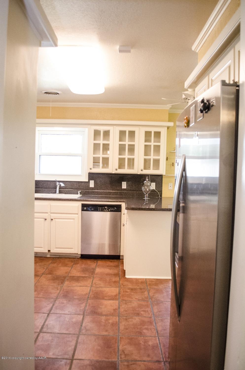 6312 Elmhurst Road Amarillo, TX 79106 - Photo 34 of 85 a kitchen with granite countertop a refrigerator and a sink