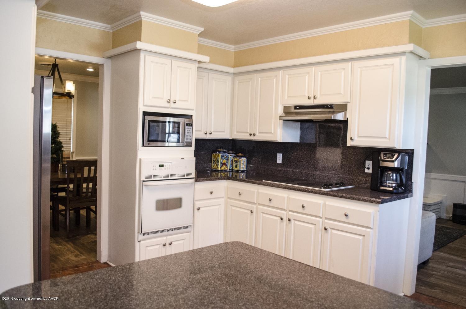 6312 Elmhurst Road Amarillo, TX 79106 - Photo 37 of 85 a kitchen with granite countertop white cabinets and stainless steel appliances