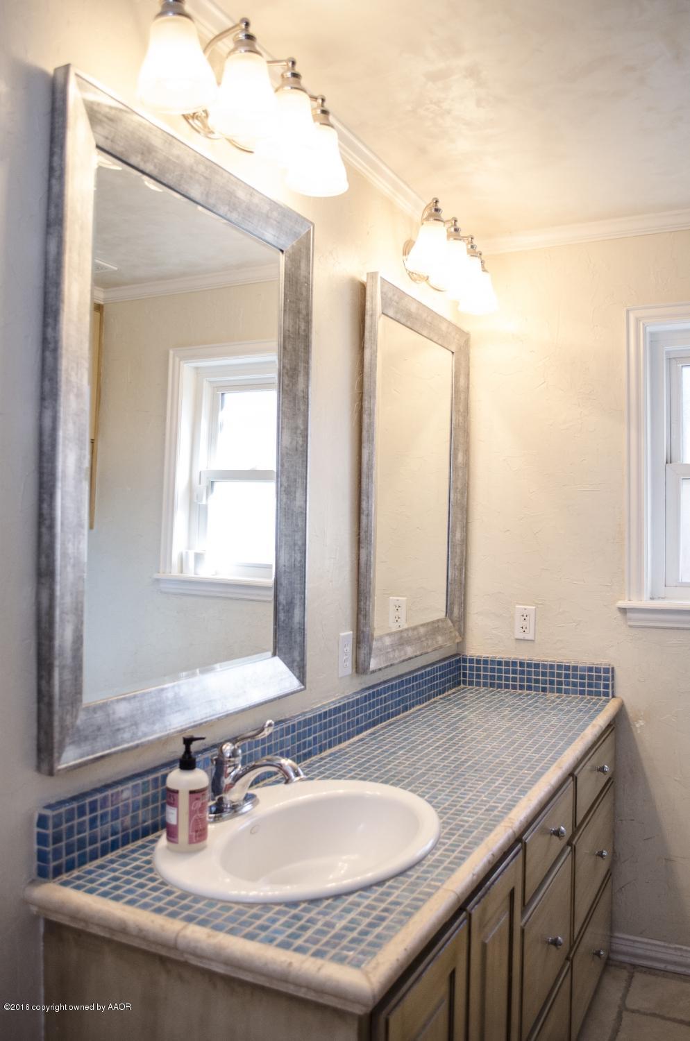 6312 Elmhurst Road Amarillo, TX 79106 - Photo 58 of 85 a bathroom with a granite countertop sink and a mirror