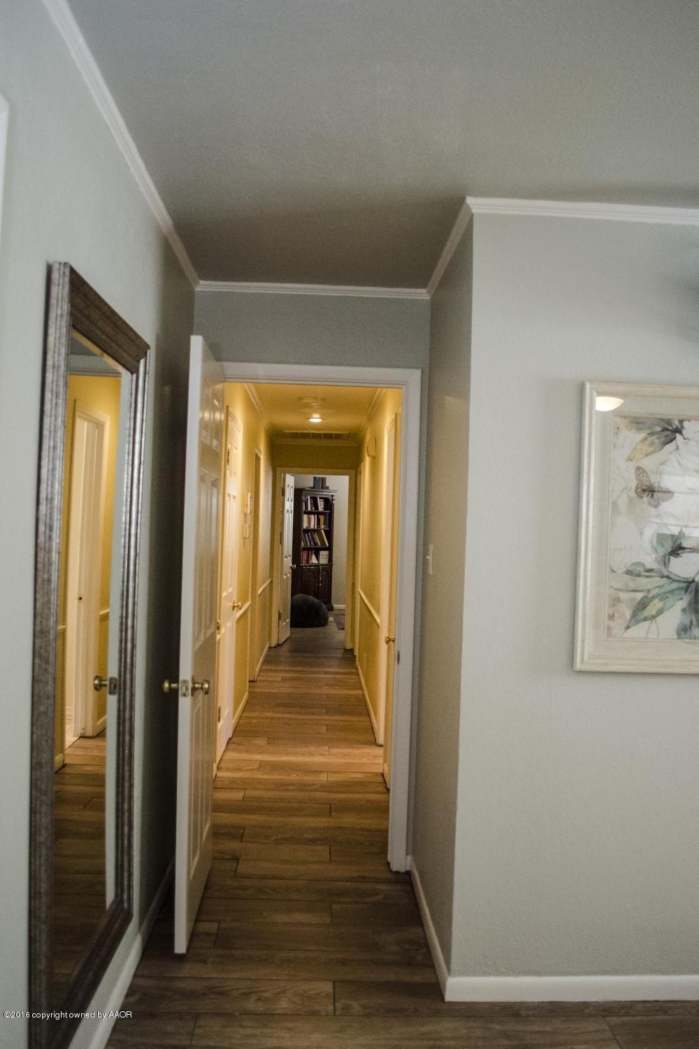 6312 Elmhurst Road Amarillo, TX 79106 - Photo 71 of 85 a view of a hallway with wooden floor and staircase