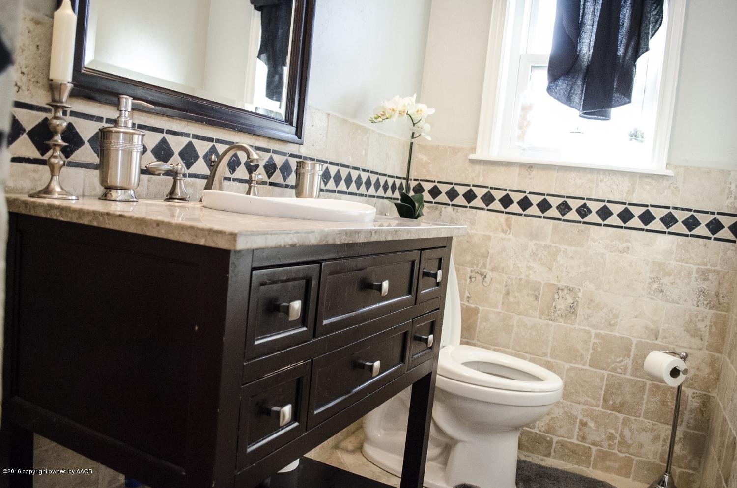6312 Elmhurst Road Amarillo, TX 79106 - Photo 77 of 85 a bathroom with a sink a toilet and a mirror