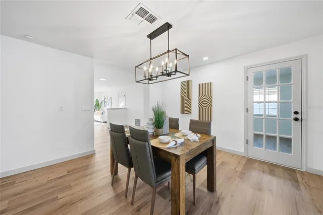 a view of a dining room with furniture a chandelier and wooden floor