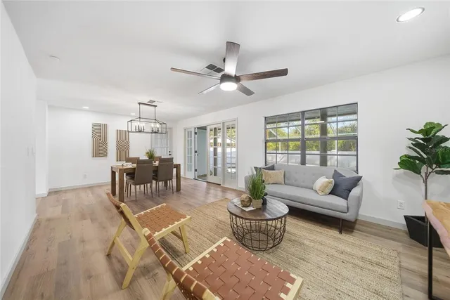 a living room with furniture a chandelier and a table