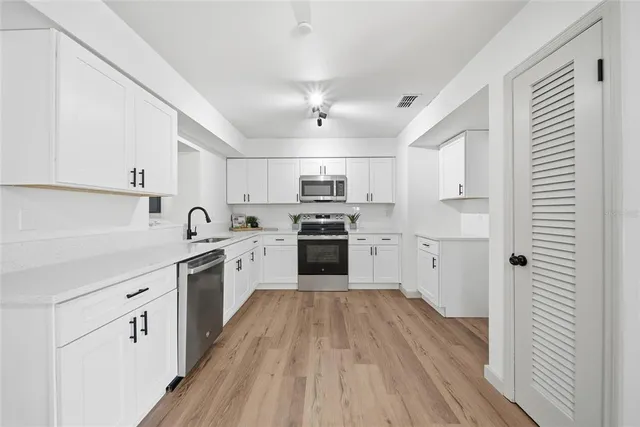 a kitchen with granite countertop a sink and steel appliances