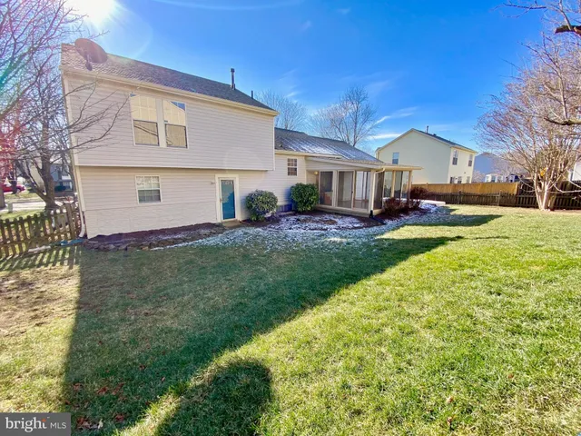 a view of a house with a big yard and large tree