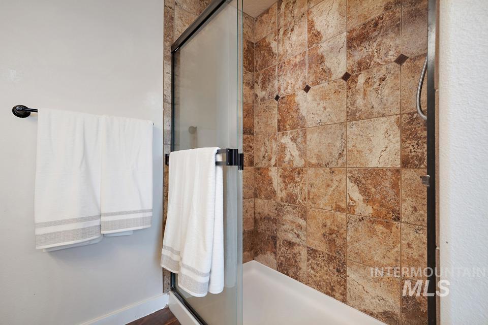 23800 Breyer Road Caldwell, ID 83607 - Photo 25 of 50 Shower enclosure featuring a framed glass door with a matte black handle and a tiled interior