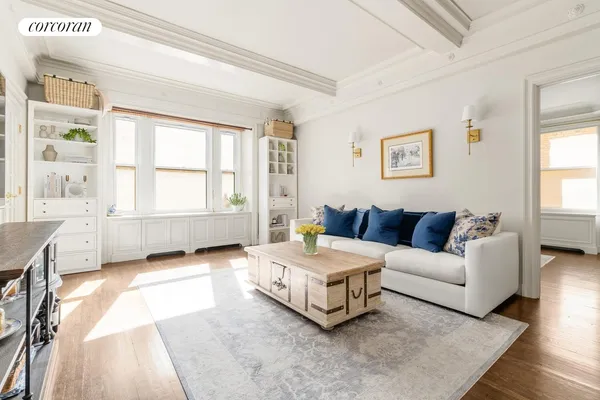 a spacious bedroom with a bed couch and a window with wooden floor