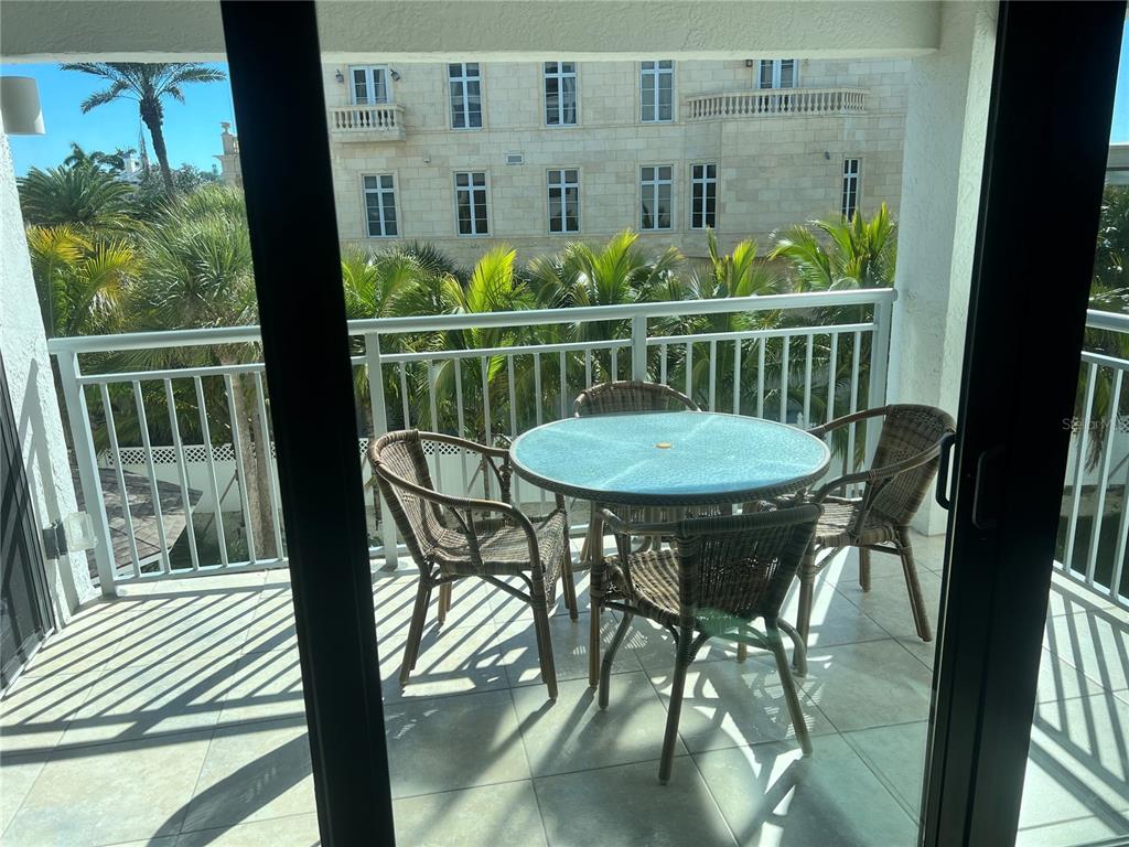 1001 Point Of Rocks Road, Unit 310 Sarasota, FL 34242 - Photo 14 of 35 a view of a balcony dining table and chairs