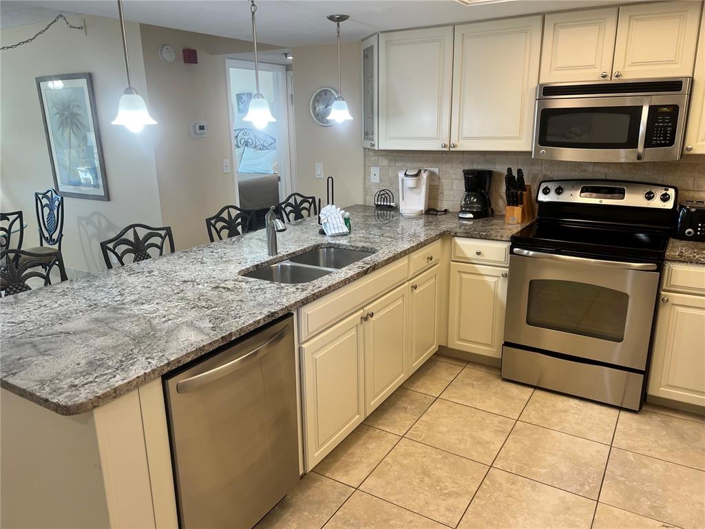 1001 Point Of Rocks Road, Unit 310 Sarasota, FL 34242 - Photo 5 of 35 a kitchen with a sink stove and cabinets