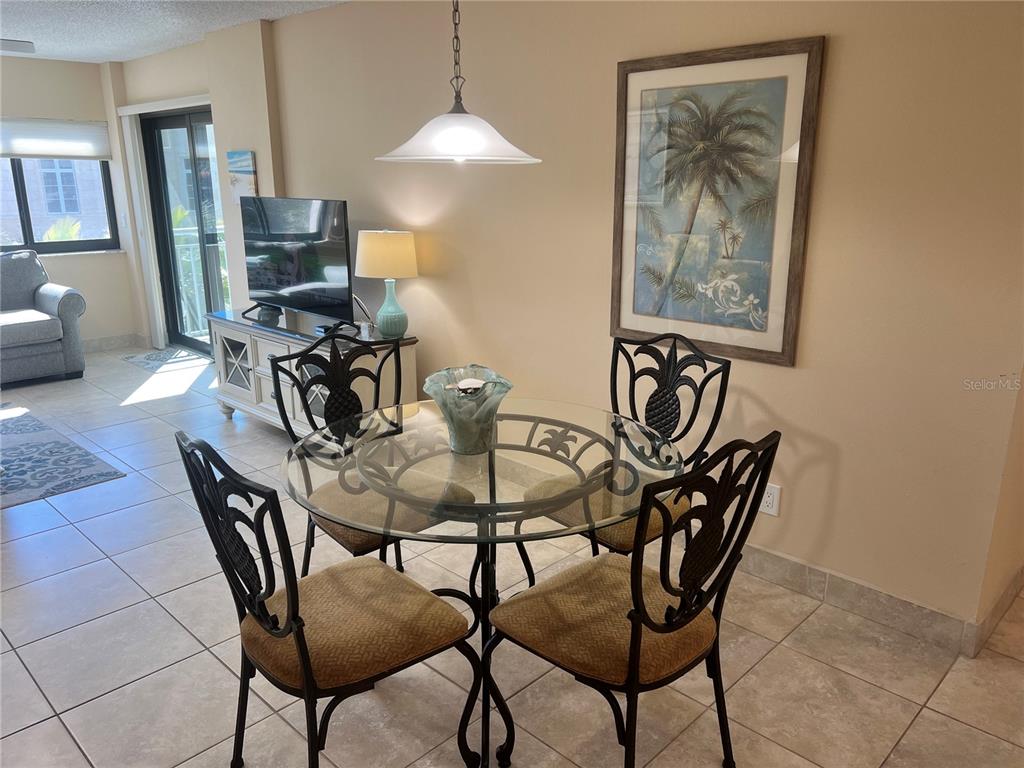 1001 Point Of Rocks Road, Unit 310 Sarasota, FL 34242 - Photo 7 of 35 a view of a dining room with furniture and a chandelier fan