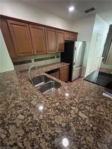 a kitchen with stainless steel appliances a refrigerator and a sink