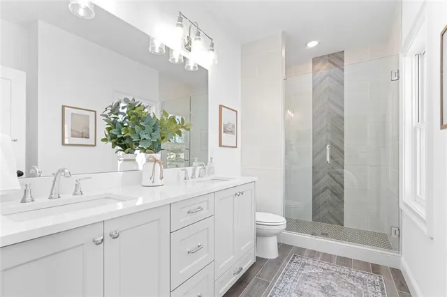 a bathroom with a double vanity sink toilet and shower