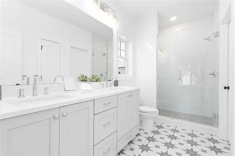 a bathroom with a double vanity sink toilet and shower