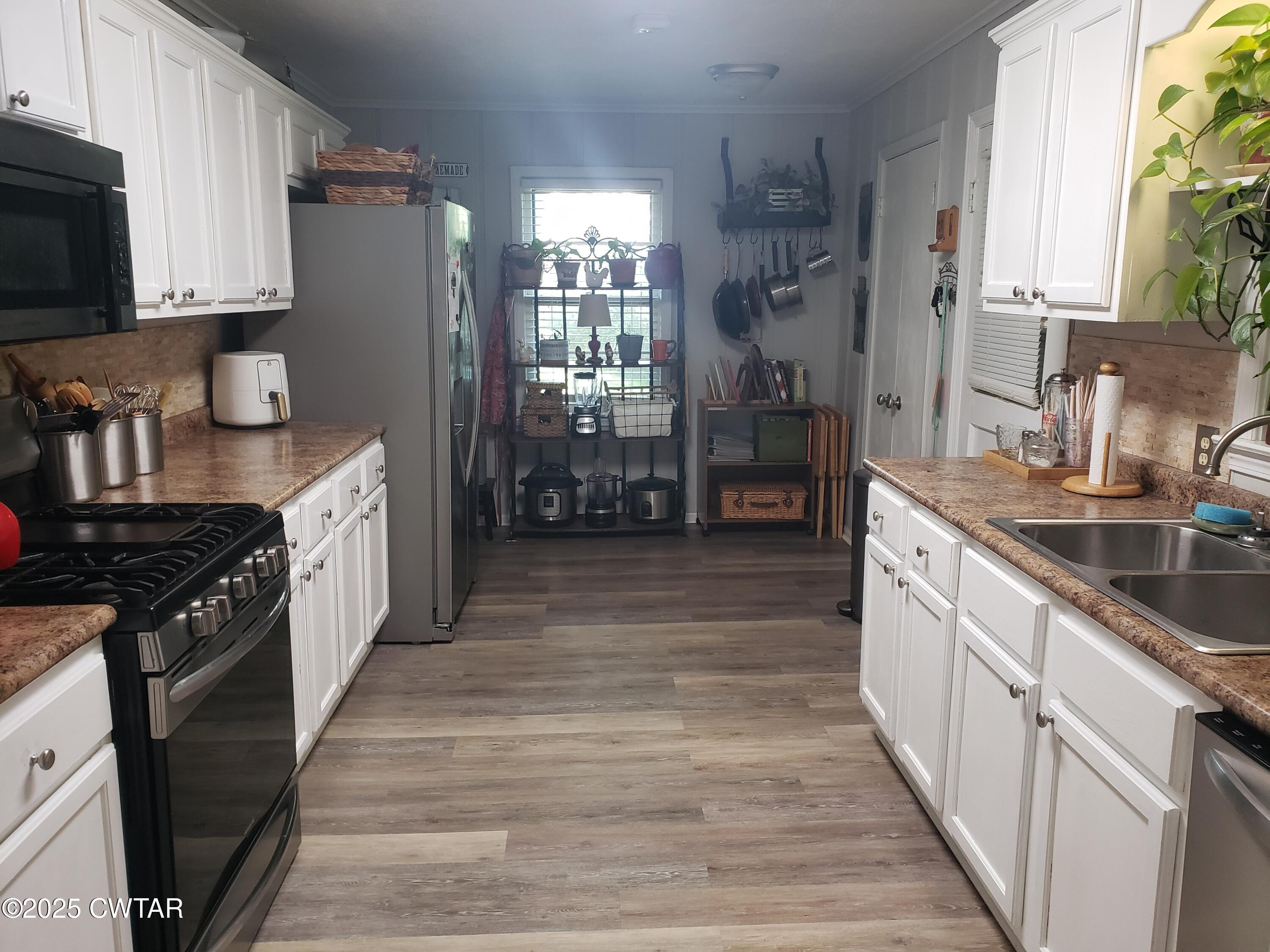 99 Montclair Drive Jackson, TN 38301 - Photo 8 of 19 a kitchen with stainless steel appliances granite countertop a sink stove refrigerator and cabinets