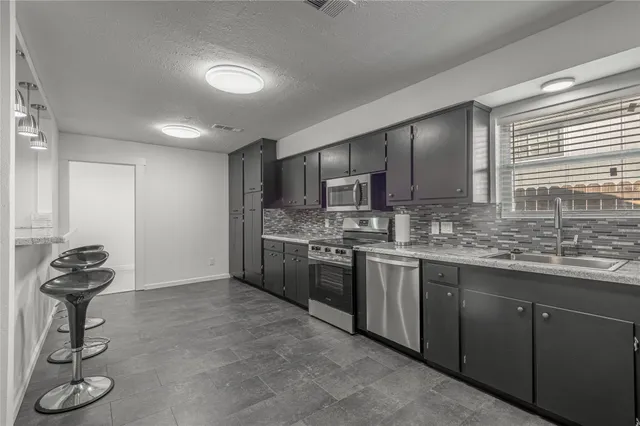 a kitchen with stainless steel appliances granite countertop a refrigerator and a sink