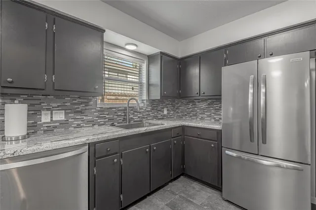 a kitchen with stainless steel appliances granite countertop a refrigerator and a stove top oven