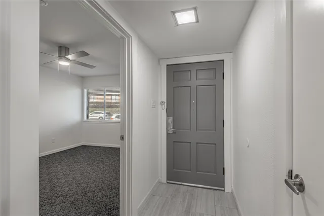 an empty room with a window and a fan