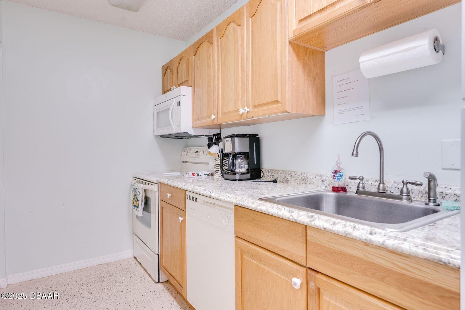 101 Bent Tree Drive, Unit 33 Daytona Beach, FL 32114 - Photo 22 of 27 a kitchen with stainless steel appliances granite countertop a sink a stove and white cabinets