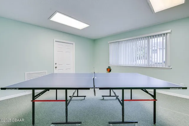 a room with pool table and windows