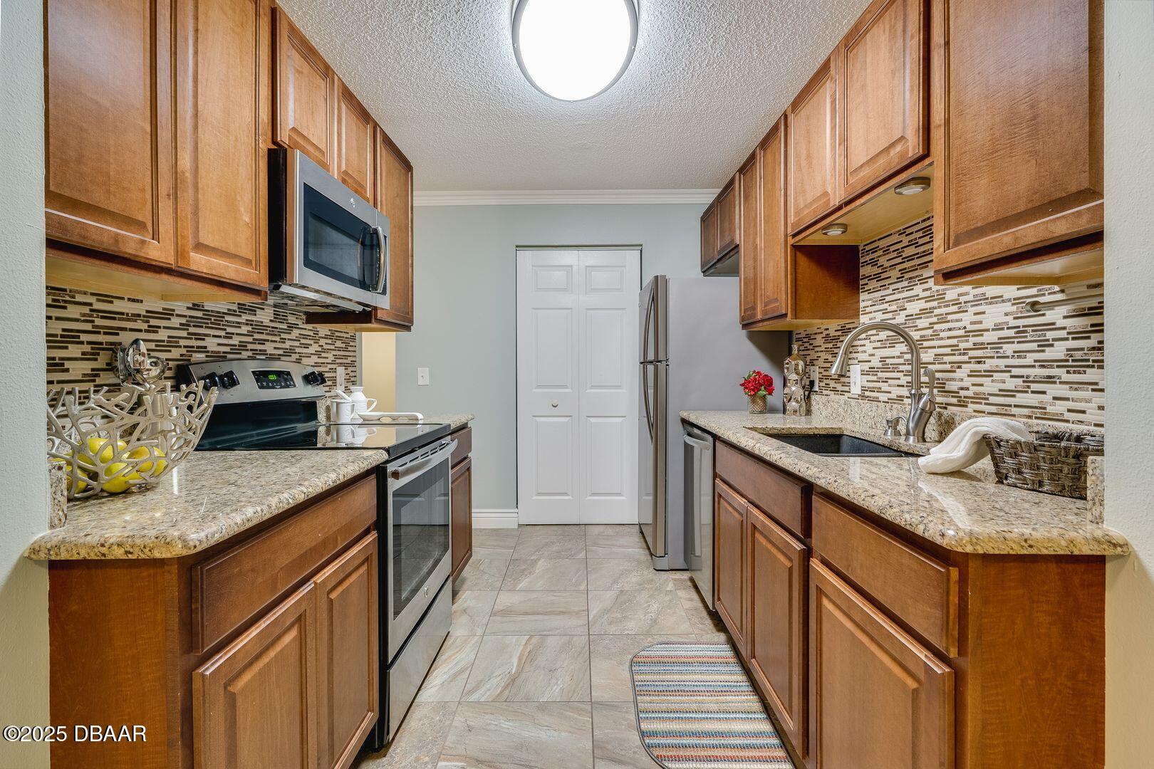 101 Bent Tree Drive, Unit 33 Daytona Beach, FL 32114 - Photo 4 of 27 a kitchen with stainless steel appliances granite countertop a sink stove and cabinets