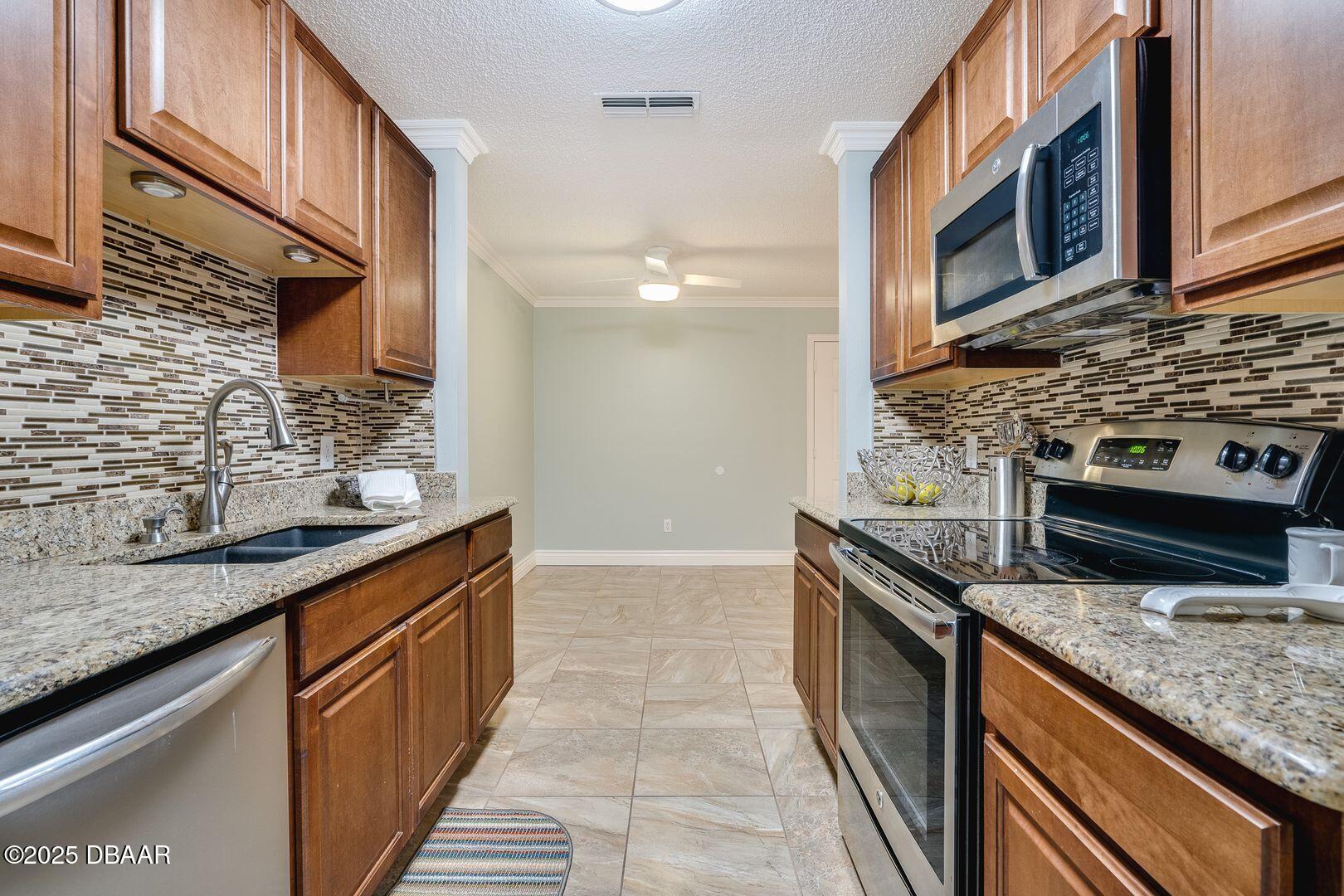 101 Bent Tree Drive, Unit 33 Daytona Beach, FL 32114 - Photo 5 of 27 a kitchen with stainless steel appliances granite countertop a stove a sink and a microwave