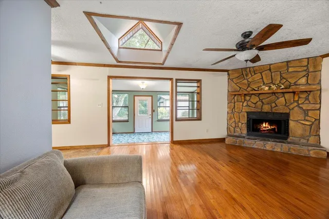 a living room with a fireplace furniture a ceiling fan and a rug